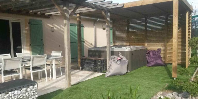 Pergola en bois avec mobilier de jardin blanc et spa extérieur sur pelouse