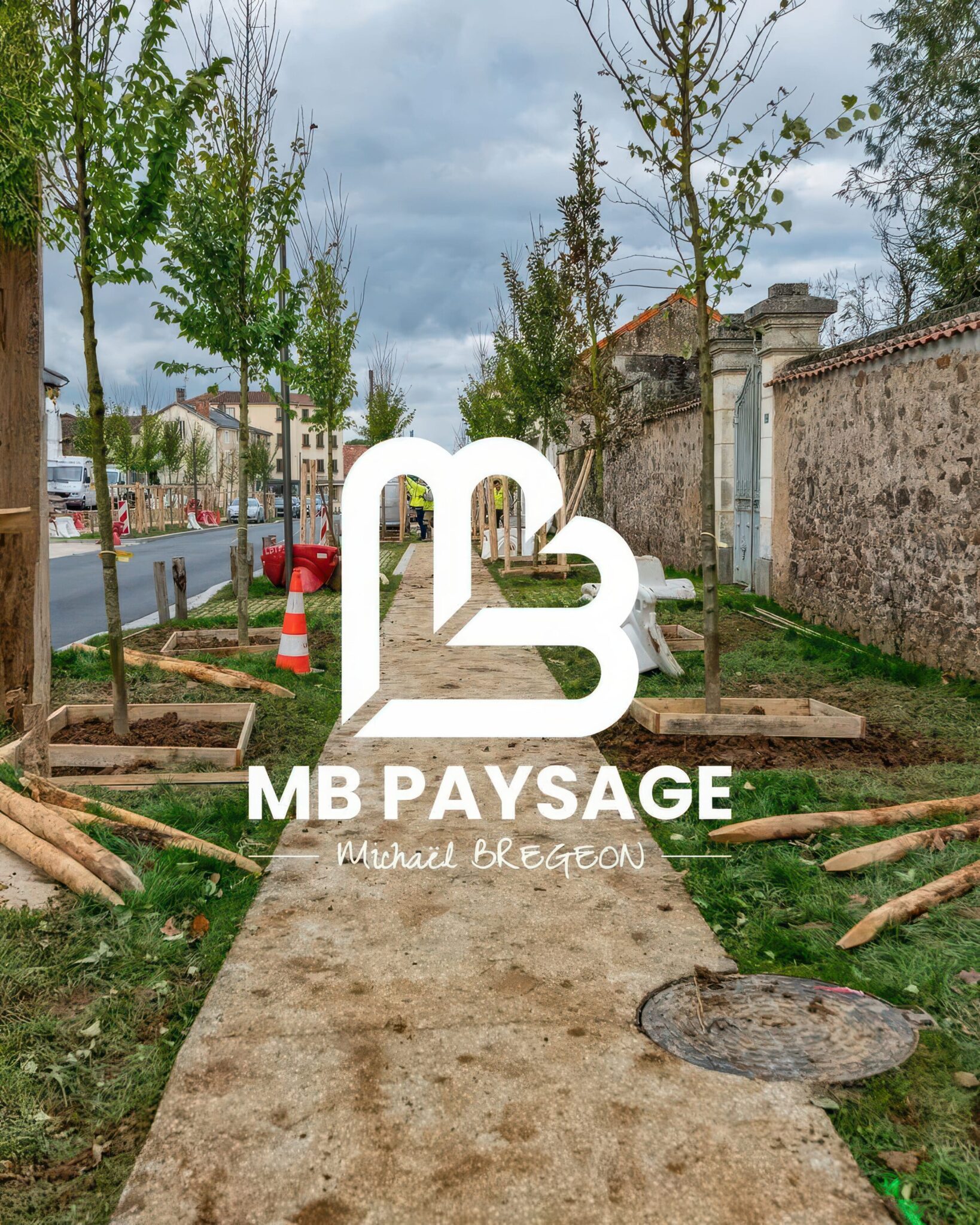 Allée urbaine en cours d'aménagement paysager avec jeunes arbres plantés et carré de terre
