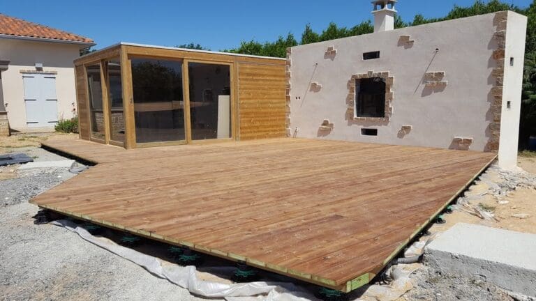 Abris de jardin en bois avec une large terrasse en bois devant
