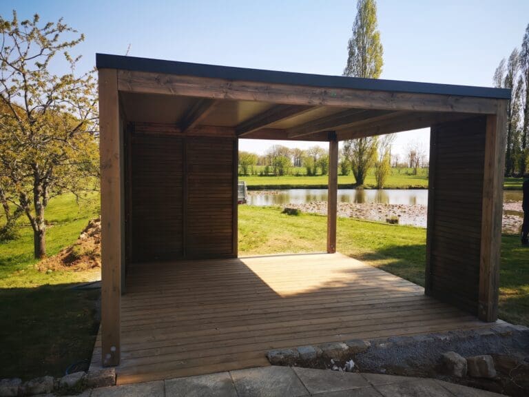 Pergola en bois avec vue sur un plan d'eau et un paysage verdoyant