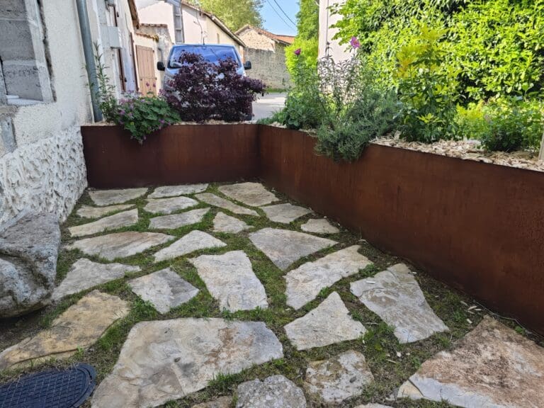Aménagement d'un petit espace extérieur avec dalles irrégulières et jardinières en métal