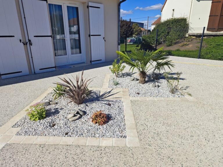 Deux carrés de jardin proprement aménagés avec gravier blanc et diverses plantes devant une maison
