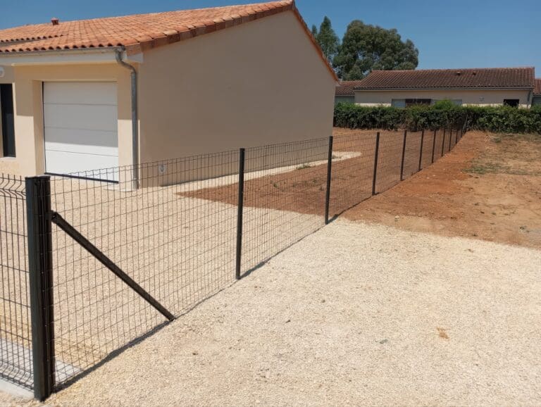 Clôture grillagée noire installée autour d'une maison avec toit en tuiles