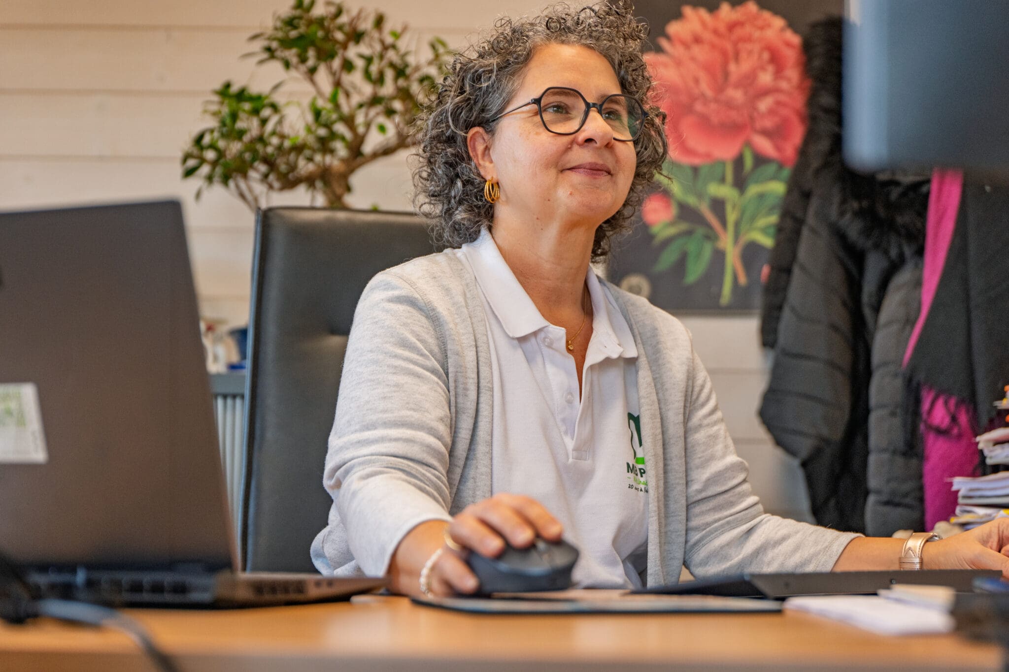 Femme souriante portant des lunettes travaillant sur ordinateur dans un bureau